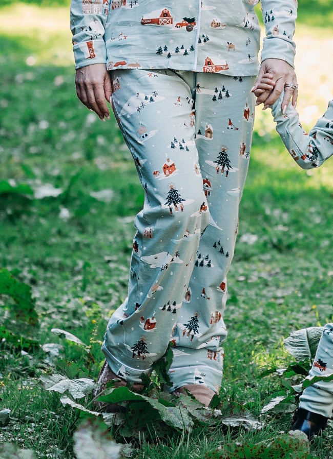 Family of four wearing matching pajamas outdoors in a natural setting
