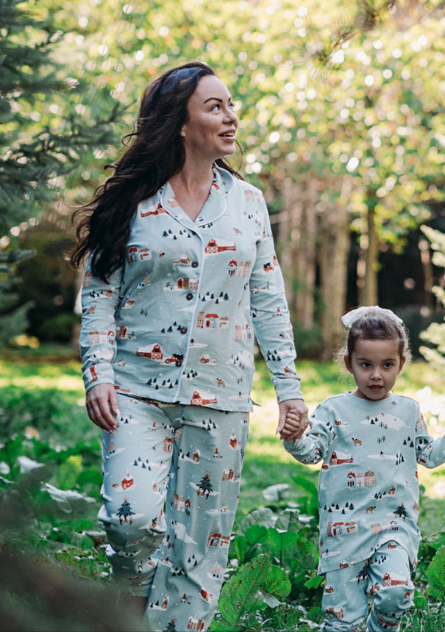 Woman and child wearing matching pajamas in a forest setting