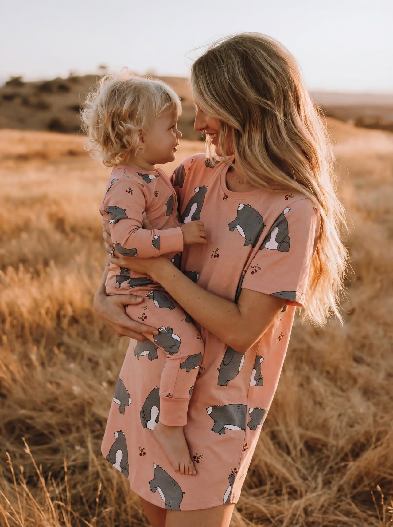 Woman and child in matching outfits standing in a field